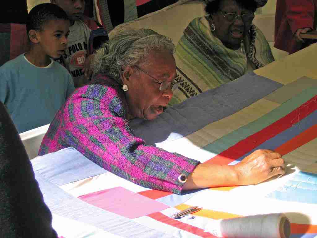 Woman sewing quilt by hand