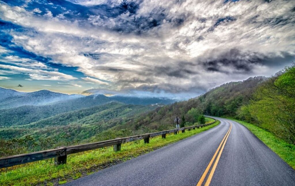 Curving two-lane road through the mountains expresses the joy of Blue Ridge Travel.