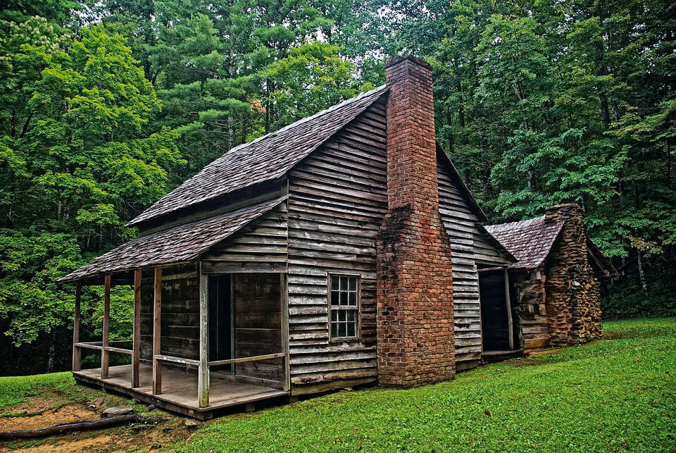 Brick and hewn stone chimneys on a historic cabin that illustrate the higher-end form of an Appalachian cabin chimney.