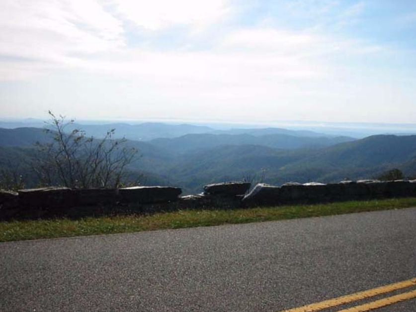Stone guardwall and distant ridges viewed from a Parkway overlook.