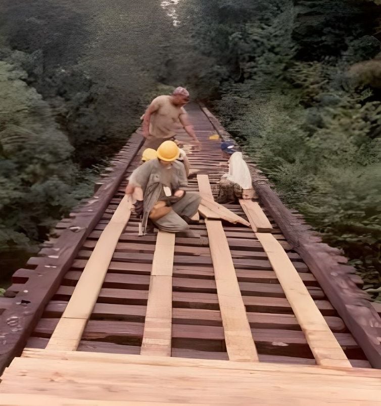 Workers replacing wooden decking on a trestle along the Virginia Creeper Trail rail corridor.