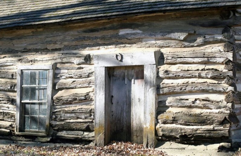 Log cabin doorway with a horseshoe fixed above the doorframe.