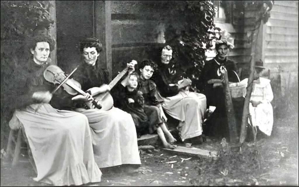 Appalachian fiddle tunes played by a family group seated together outside a rural home