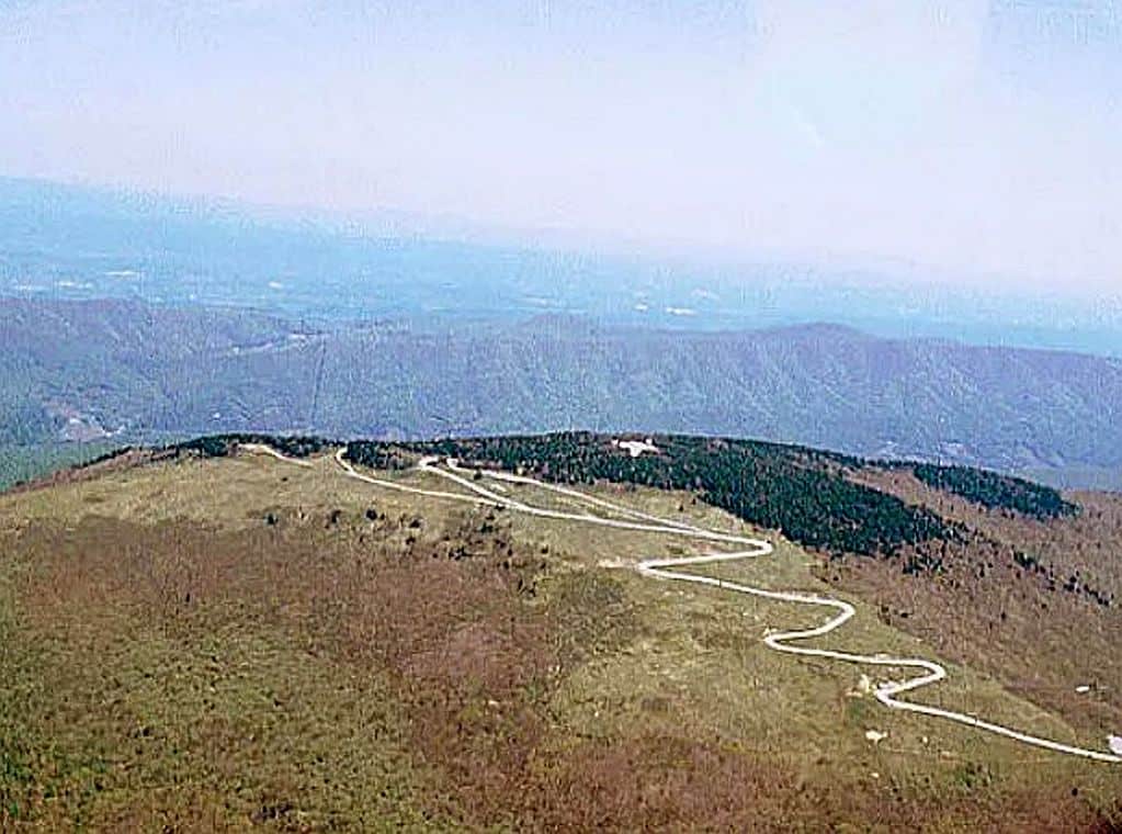 Winding mountain road climbing through switchbacks toward higher elevation