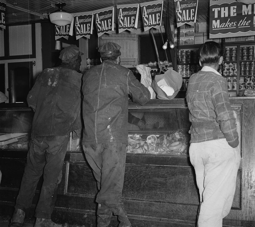 Coal miners standing at a company store counter in an Appalachian coal camp