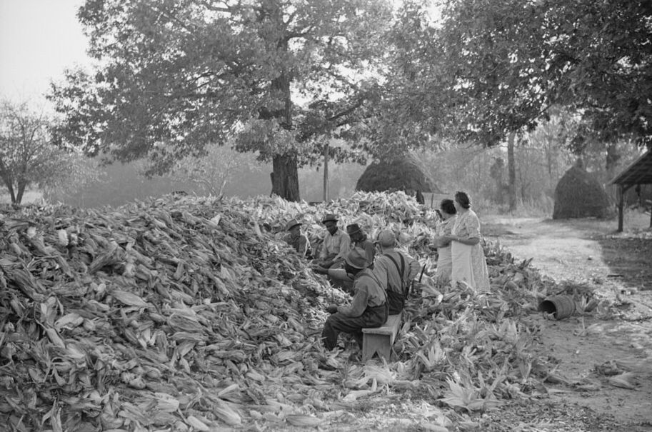 Corn shucking scene showing neighbors working together during an Appalachian work gathering