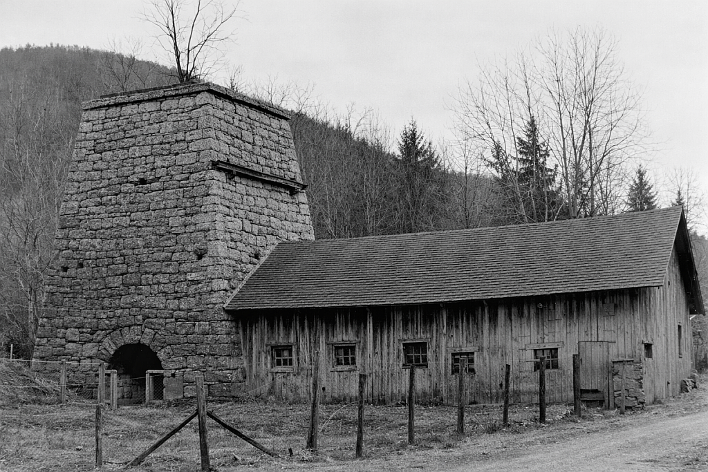 Iron furnace stack with adjacent wooden work building and roofed structure