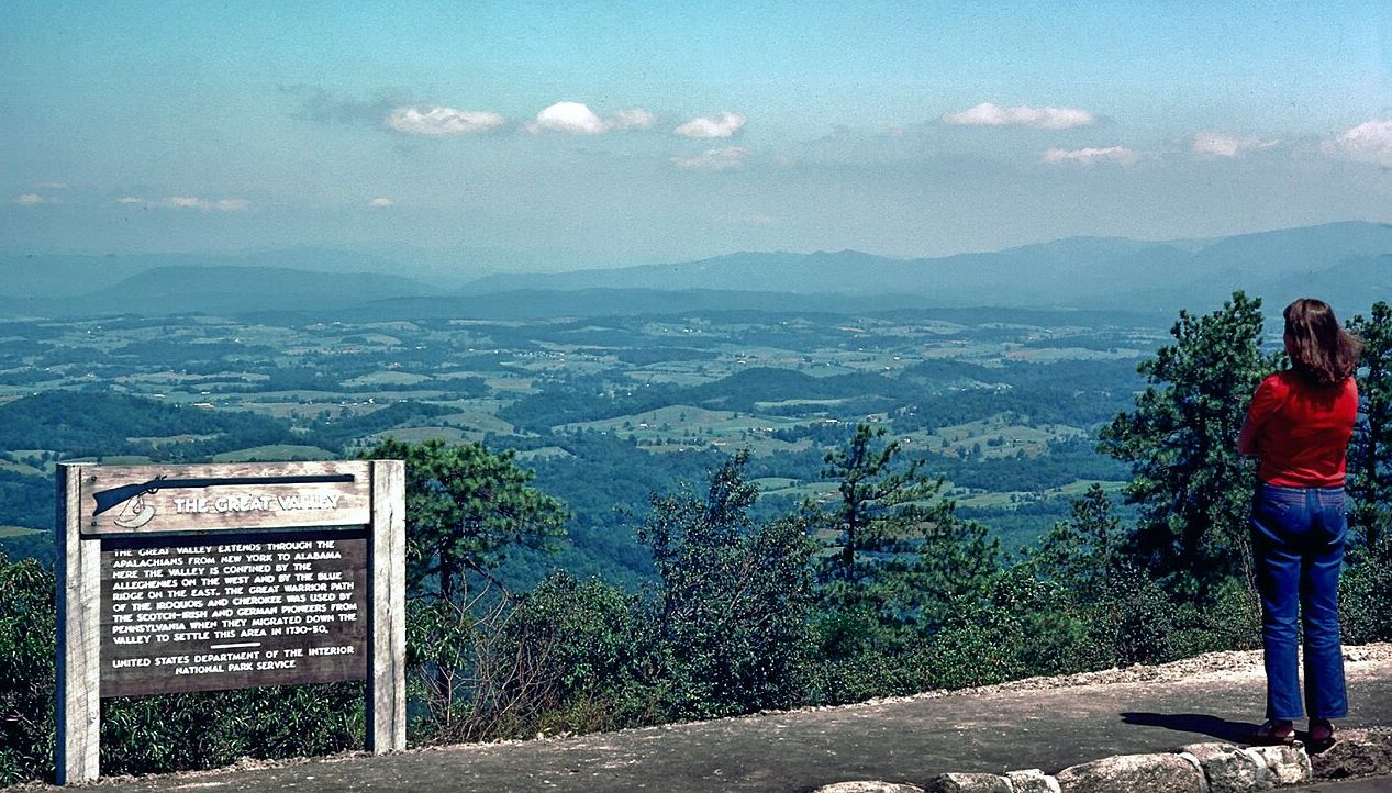 Blue Ridge Parkway overlook above the Great Valley with visitor viewing layered mountain ridges