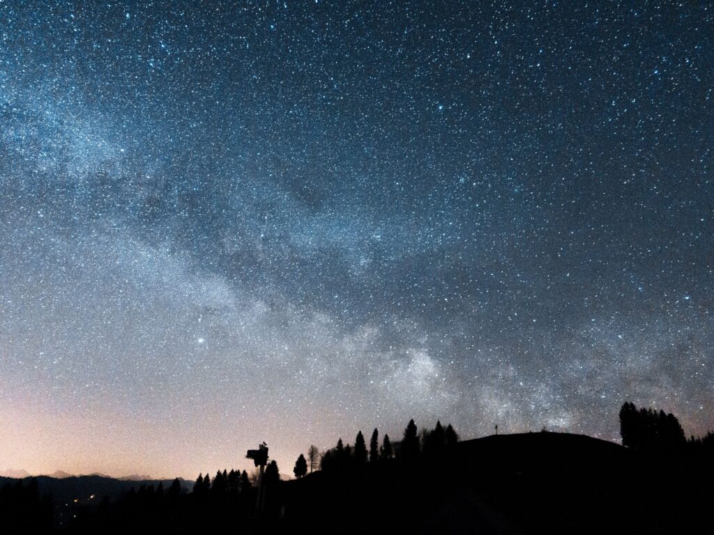 Dark mountain ridgeline beneath a dense field of stars