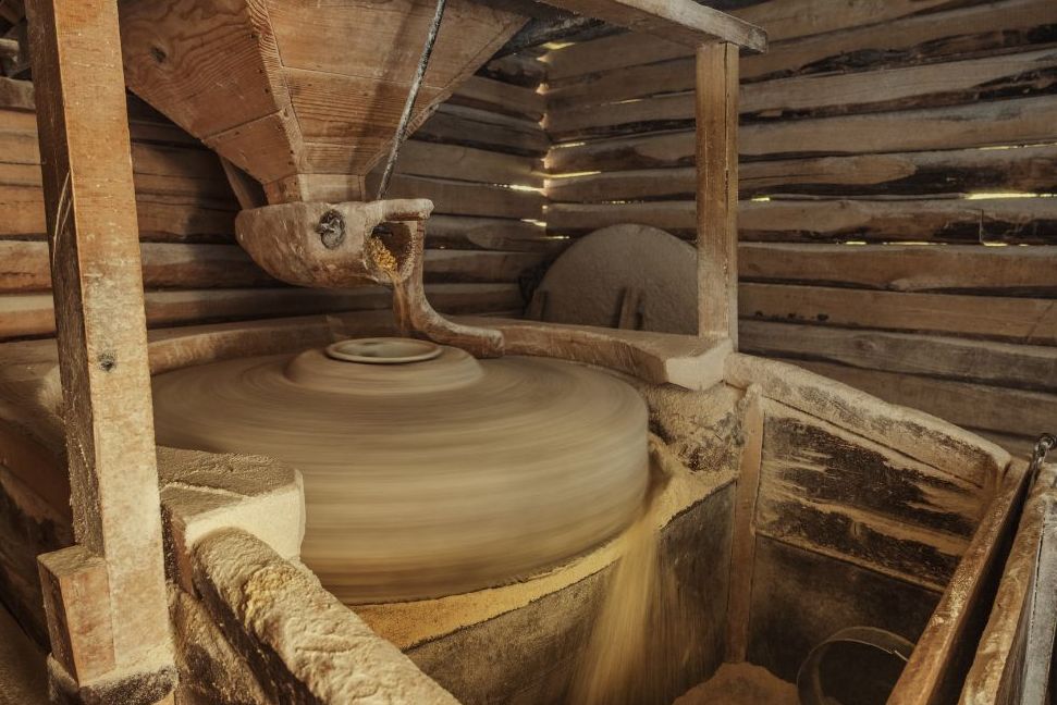 Millstones grinding grain inside an Appalachian grist mill