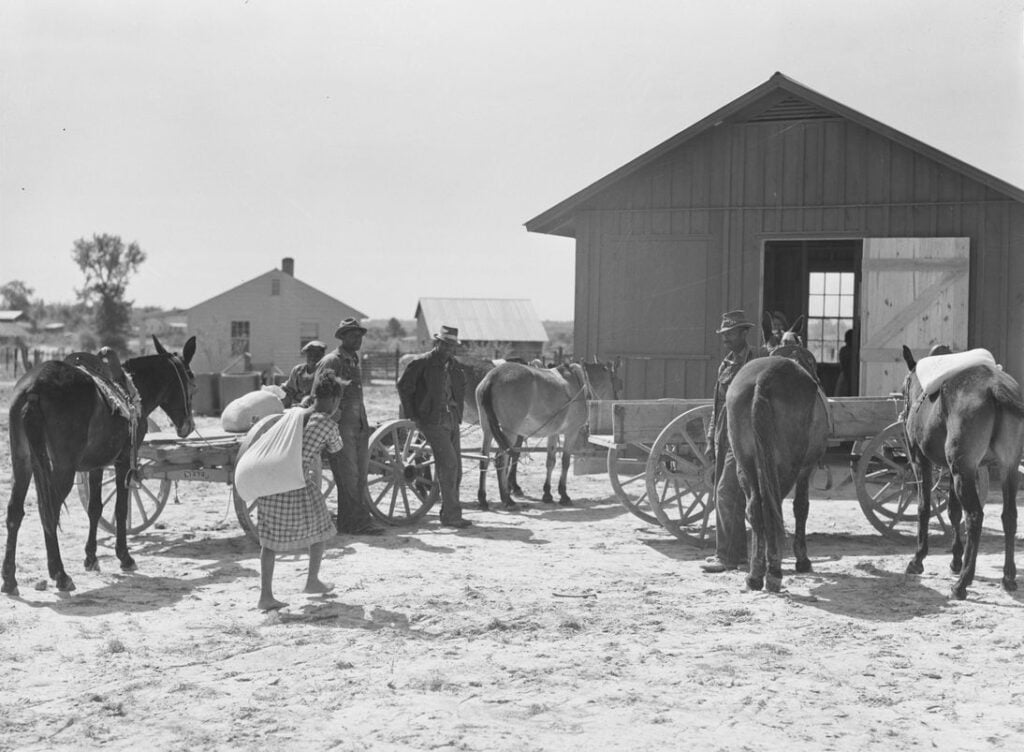 Farmers waiting with wagons outside a rural mill and trading center