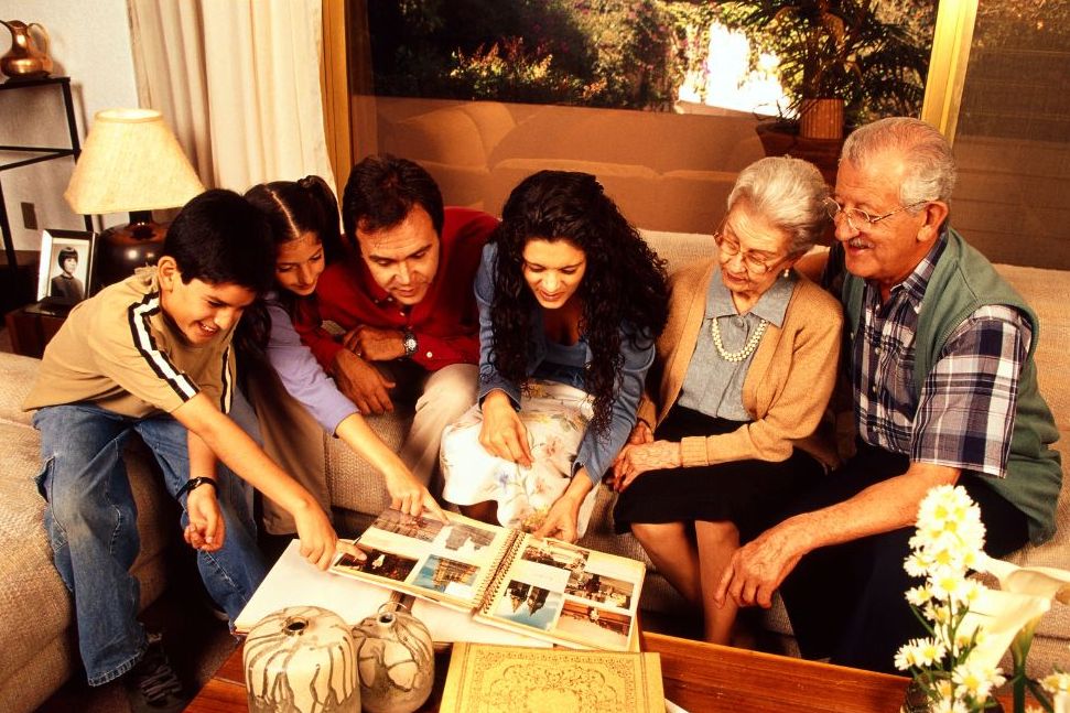 Family sharing photographs and stories around a photo album