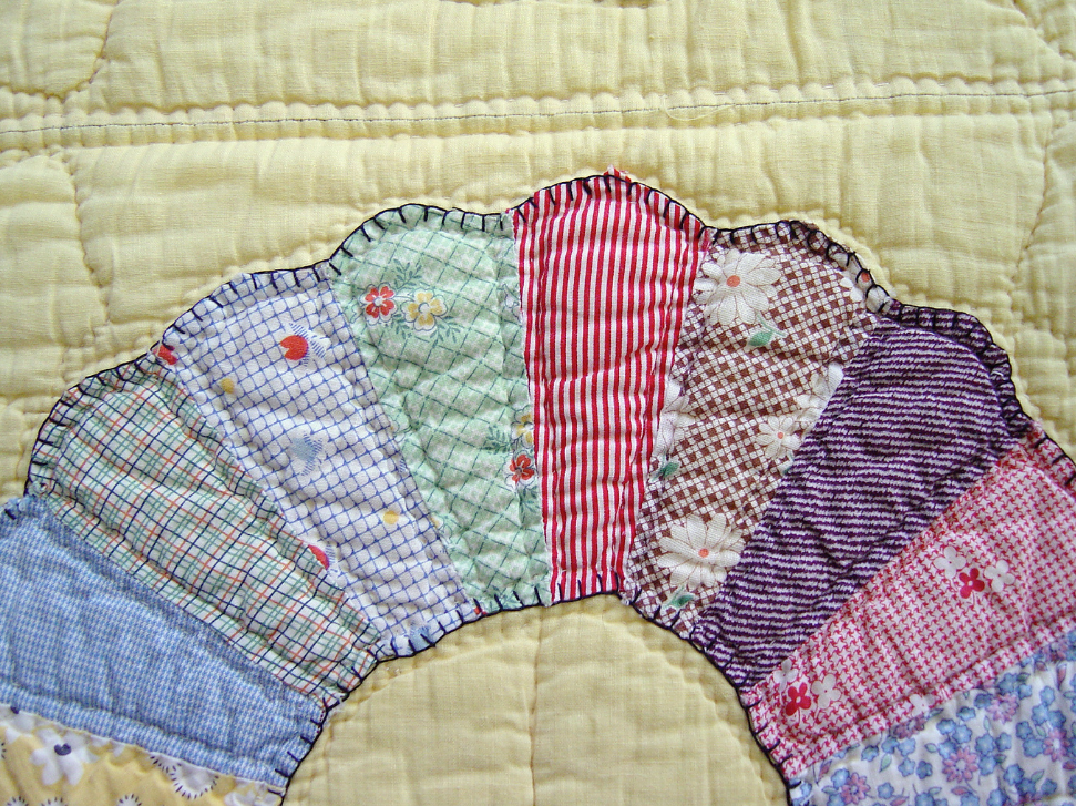 Curved quilting stitches follow the shapes of a colorful fan design.